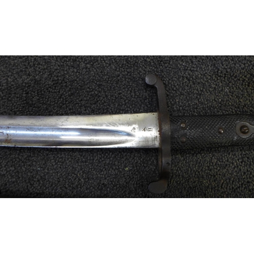 834 - A Victorian military bayonet with scabbard, marks including WD with broad arrow