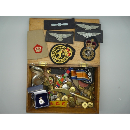 898 - A collection of military uniform badges and buttons, a trench art letter opener, etc.