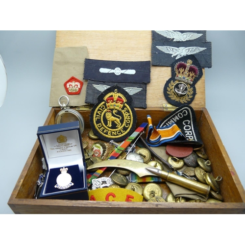 898 - A collection of military uniform badges and buttons, a trench art letter opener, etc.