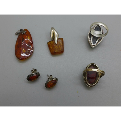 972 - Two silver and amber rings, two silver and amber pendants and a pair of earrings