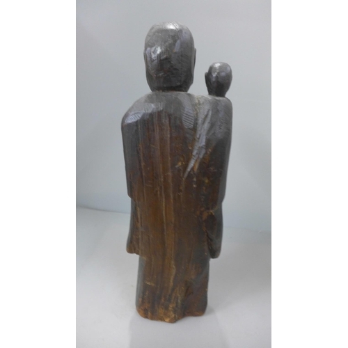 792 - A late 19th century/early 20th century carved wooden figure of a monk and young monk 36cm