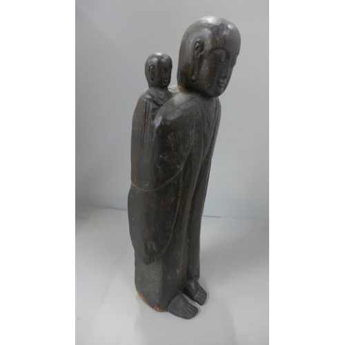 792 - A late 19th century/early 20th century carved wooden figure of a monk and young monk 36cm