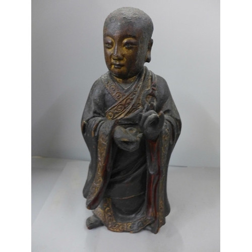 794 - A 19th Century carved wooden polychrome figure of a young monk, base split, 32cm