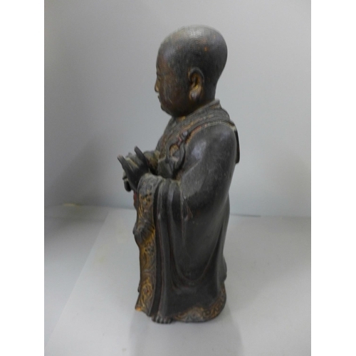 794 - A 19th Century carved wooden polychrome figure of a young monk, base split, 32cm