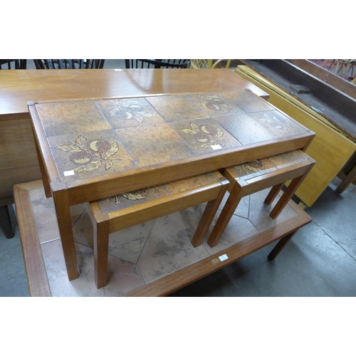 106 - A teak chest of drawers and a teak and tiled topped nest of tables