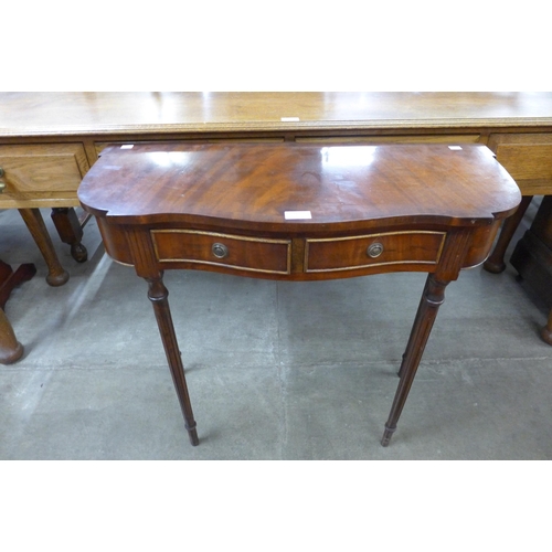 112 - A mahogany serpentine two drawer side table