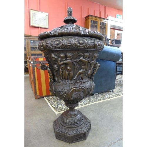 13 - A pair of large Italian style bronze campana shaped urns and covers, cast with Bacchanalian cherubs