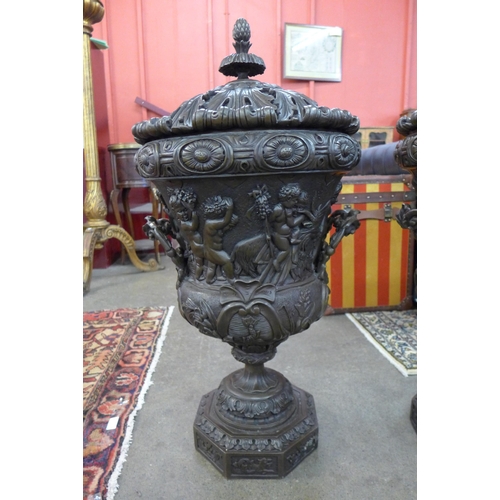 13 - A pair of large Italian style bronze campana shaped urns and covers, cast with Bacchanalian cherubs