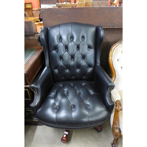 141 - A black leather revolving desk chair