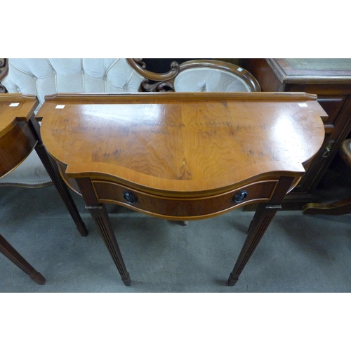 142 - A pair of yew wood single drawer console tables