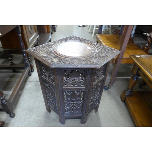 154 - An Indian carved wood corner occasional table