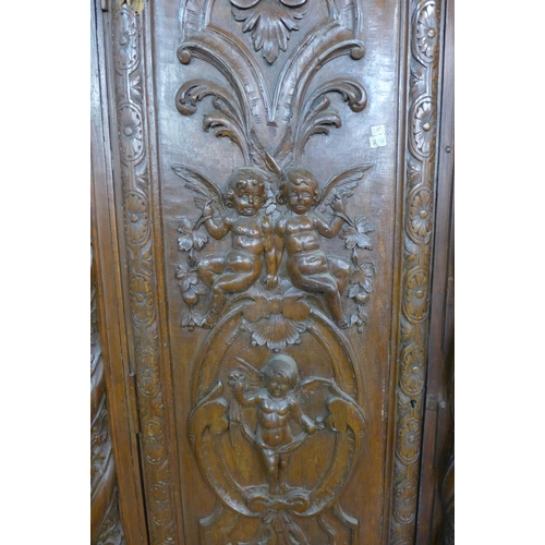 194 - An Anglo Indian heavily carved hardwood wardrobe