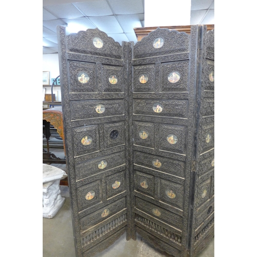 222 - An Indian carved hardwood four panel folding dressing screen