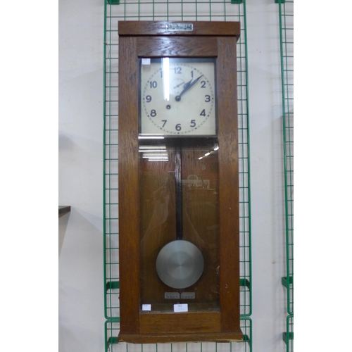 361 - A German oak master slave wall clock