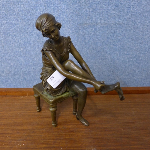 374 - An Art Deco style bronze figure of a seated lady putting on stockings