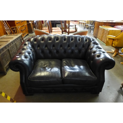 38 - A black leather Chesterfield settee