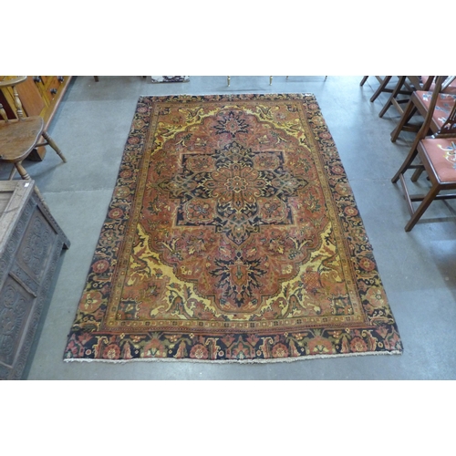 41 - An early 20th Century Persian terracotta ground Heriss rug, 255 x 177cms