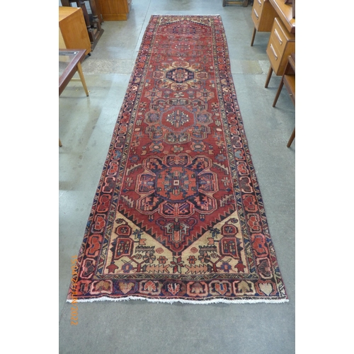 42 - A Persian red ground Herris runner rug, 427 x 115cms