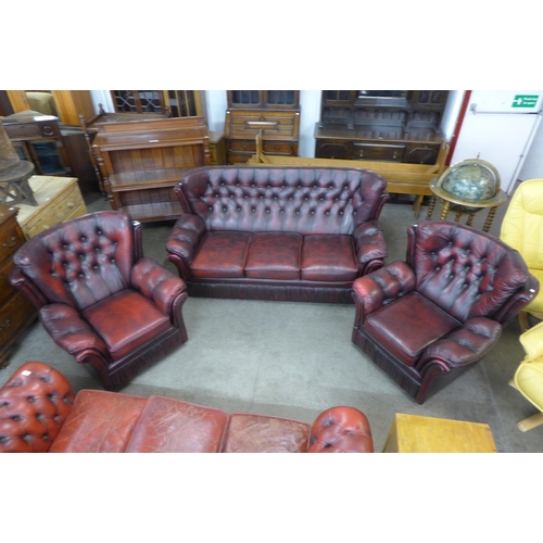 54 - An oxblood leather Chesterfield style three piece suite