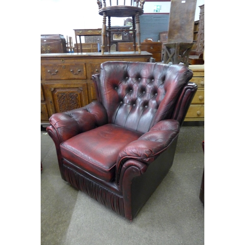 54 - An oxblood leather Chesterfield style three piece suite