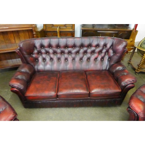 54 - An oxblood leather Chesterfield style three piece suite