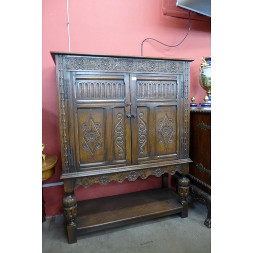 55 - An Elizabethan Revival carved oak two door livery cupboard