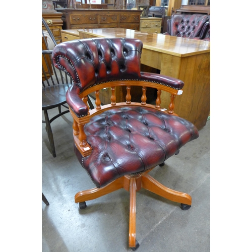 97 - A beech and burgundy leather revolving Captain's desk chair