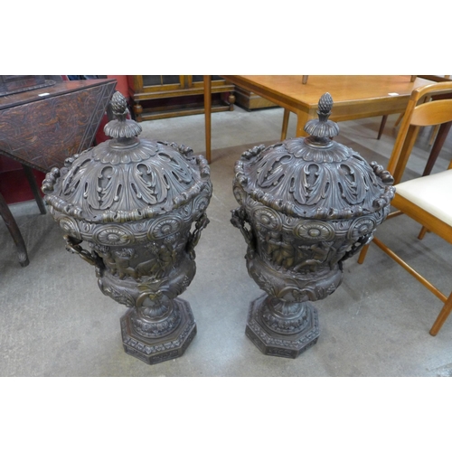 106 - A pair of large Italian style bronze campana shaped urns and covers, cast with Bacchanalian cherubs