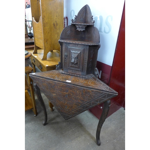 107 - A Victorian Jacobean Revival carved oak corner stand