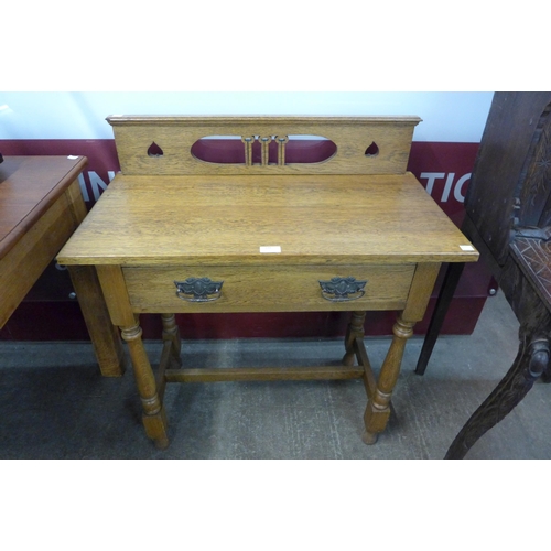 110 - An Arts and Crafts carved oak single drawer side table