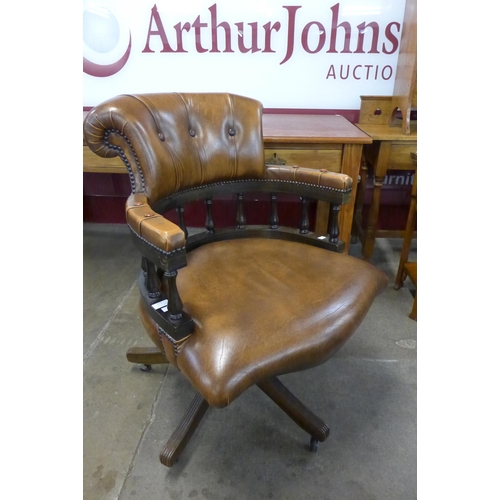 112 - A mahogany and tan leather revolving Captain's desk chair