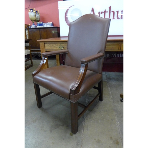 113 - A mahogany and brown leather library armchair