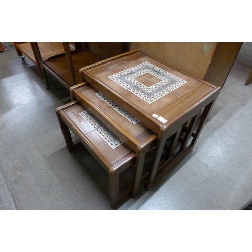 86 - A teak and tiled topped nest of tables