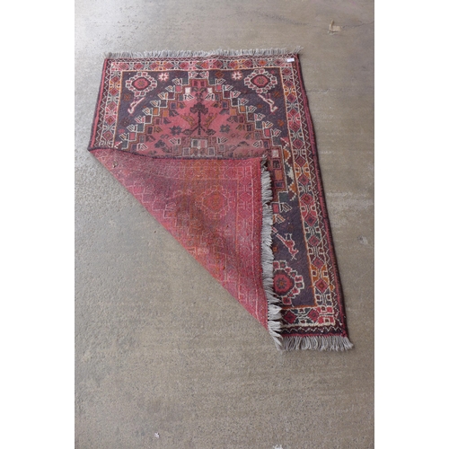 239 - An eastern hand knotted red ground rug