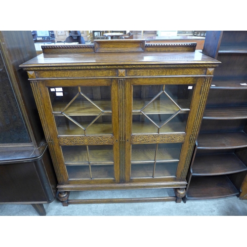 131 - An early 20th Century carved oak two door bookcase