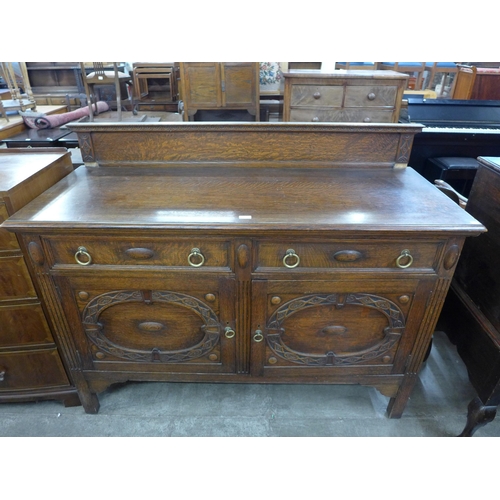 144 - An early 20th century carved oak sideboard