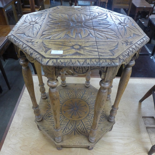 214 - A carved oak two tier octagonal occasional table