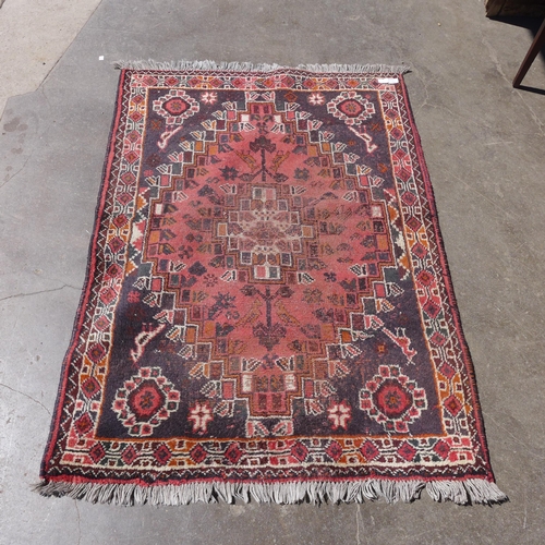 239 - An eastern hand knotted red ground rug