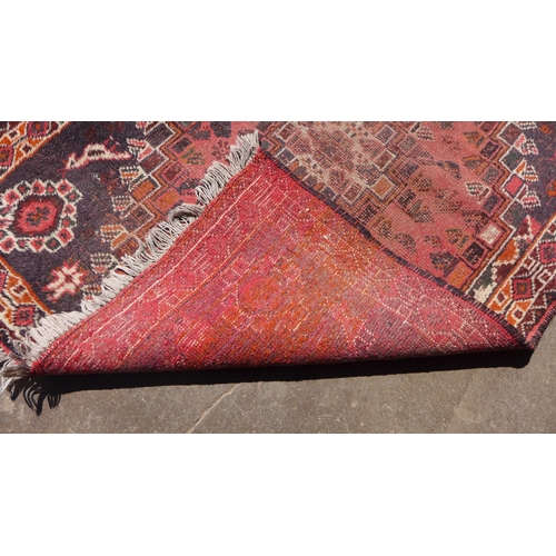 239 - An eastern hand knotted red ground rug