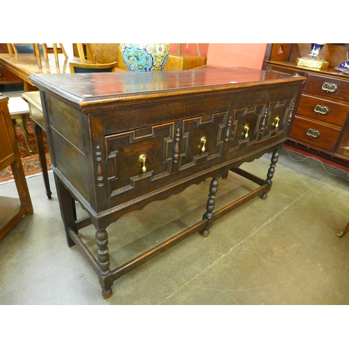 24 - An early 20th Century Jacobean Revival oak geometric moulded dresser