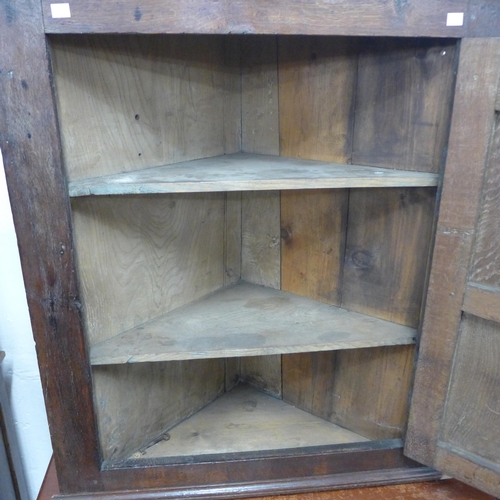 285 - A George III oak splay front wall hanging corner cupboard