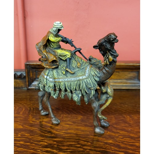 295 - A painted bronze figure of lion attacking an Arabic man and camel, manner of Franz Bergman