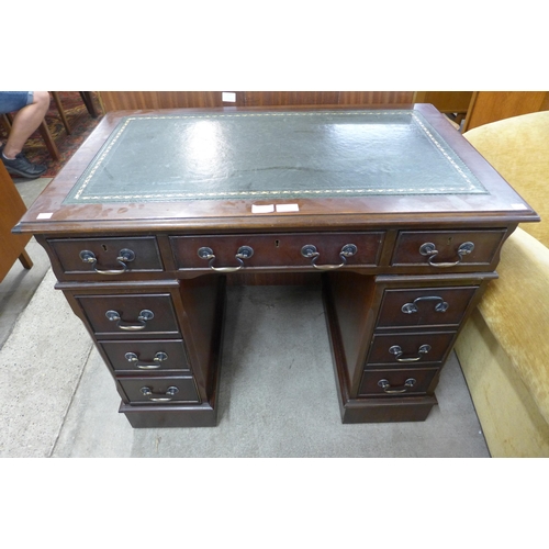 121 - A mahogany and green leather topped pedestal desk