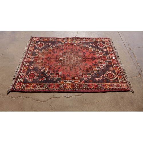 174 - An eastern hand knotted red ground rug