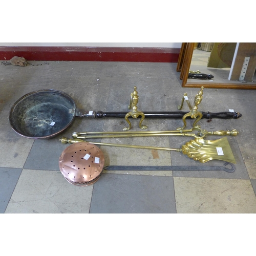 284 - A pair of brass andirons, brass fire irons, a copper chestnut roaster and a part warming pan