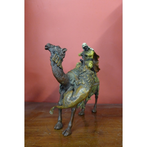 295 - A painted bronze figure of lion attacking an Arabic man and camel, manner of Franz Bergman