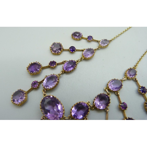 1006 - A 9ct gold and amethyst fringe necklet, set with twenty-seven stones, the largest stone 12mm x 16mm,... 