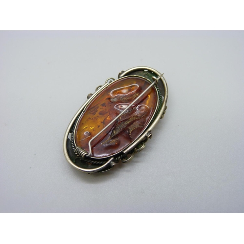 1013 - An Art Nouveau style white metal set brooch, set with amber