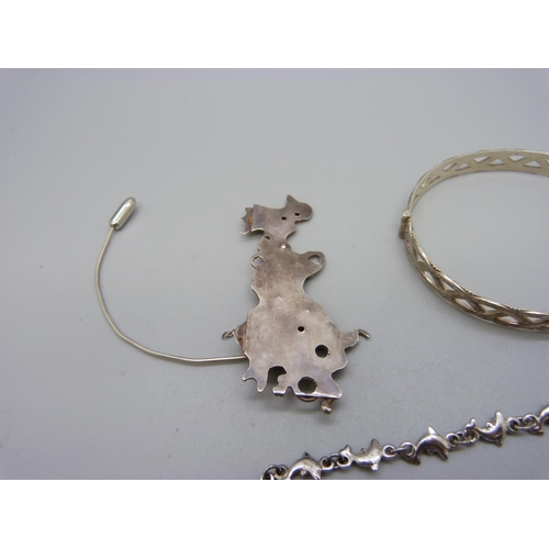 1021 - An Arts and Crafts style white metal brooch/pendant, a silver bangle and silver dolphin bracelet