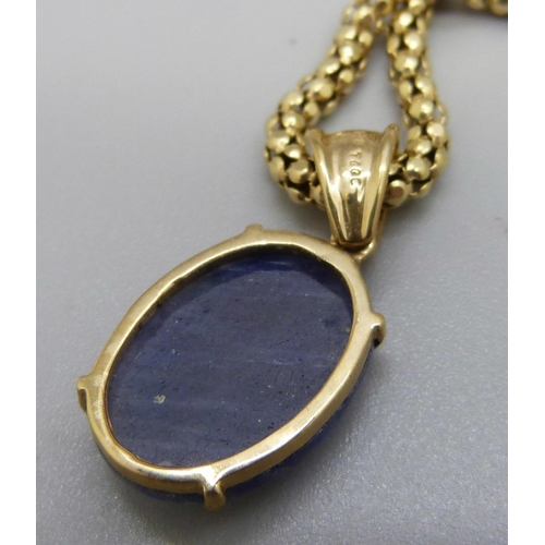 1029 - A 9ct gold faceted blue stone set pendant on a silver chain